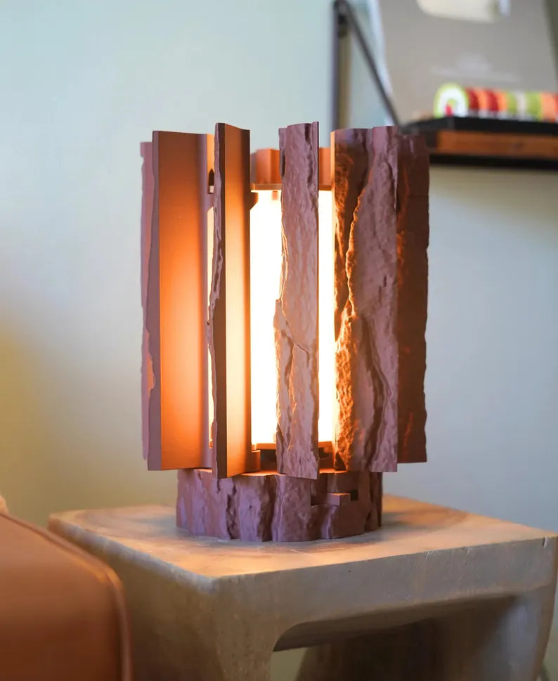 Log Table Lamp in brown on a wooden table, showcasing its unique design and natural wood-like texture by Loffa Design. Loffadesign