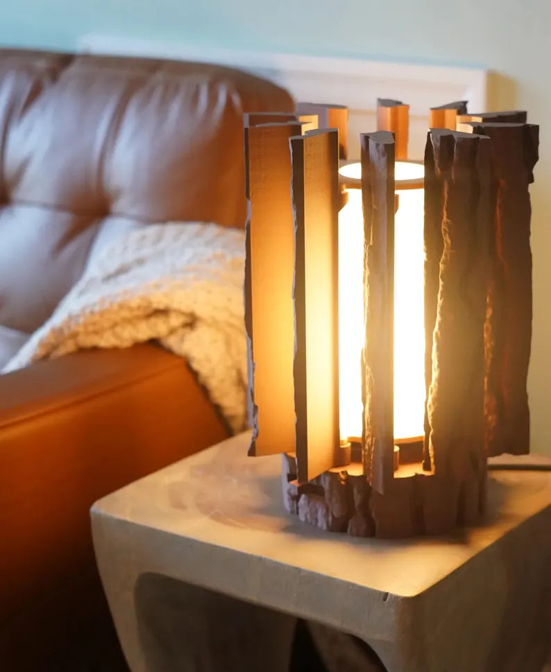 Log Table Lamp in brown on a wooden table, showcasing its unique design and natural wood-like texture by Loffa Design. Loffadesign