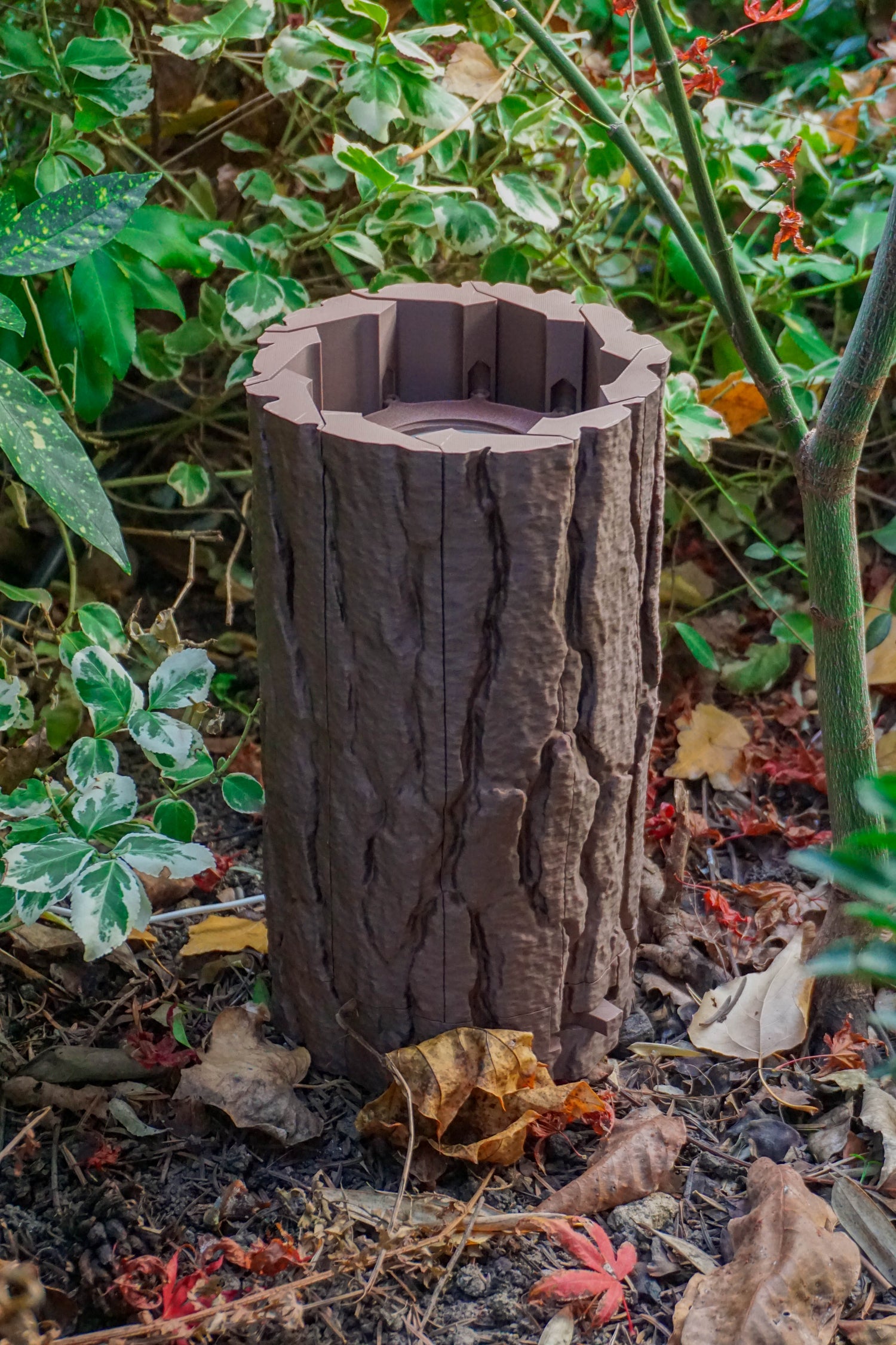 Log Table Lamp in brown on a wooden table, showcasing its unique design and natural wood-like texture by Loffa Design. Loffadesign