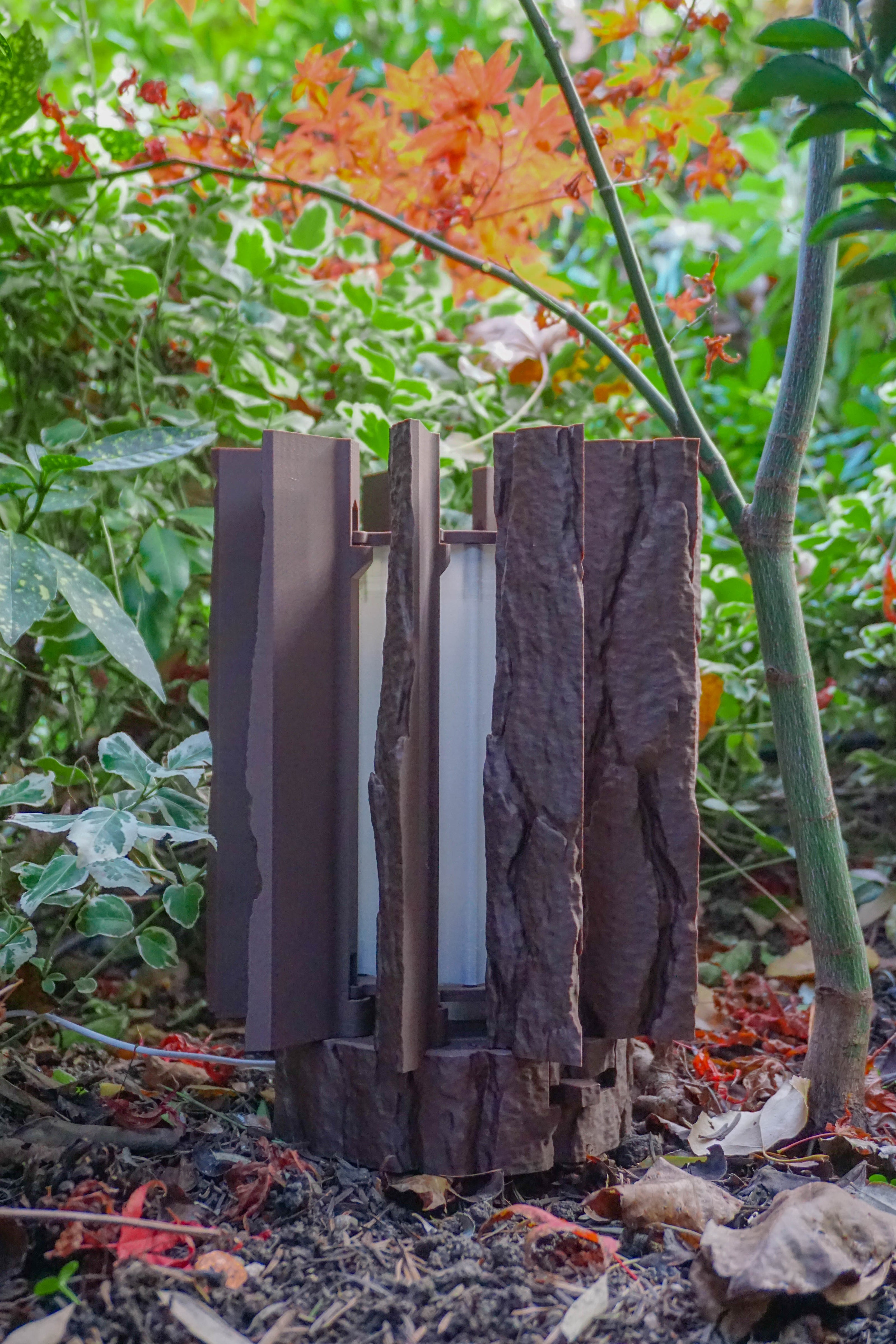 Log Table Lamp in brown on a wooden table, showcasing its unique design and natural wood-like texture by Loffa Design. Loffadesign